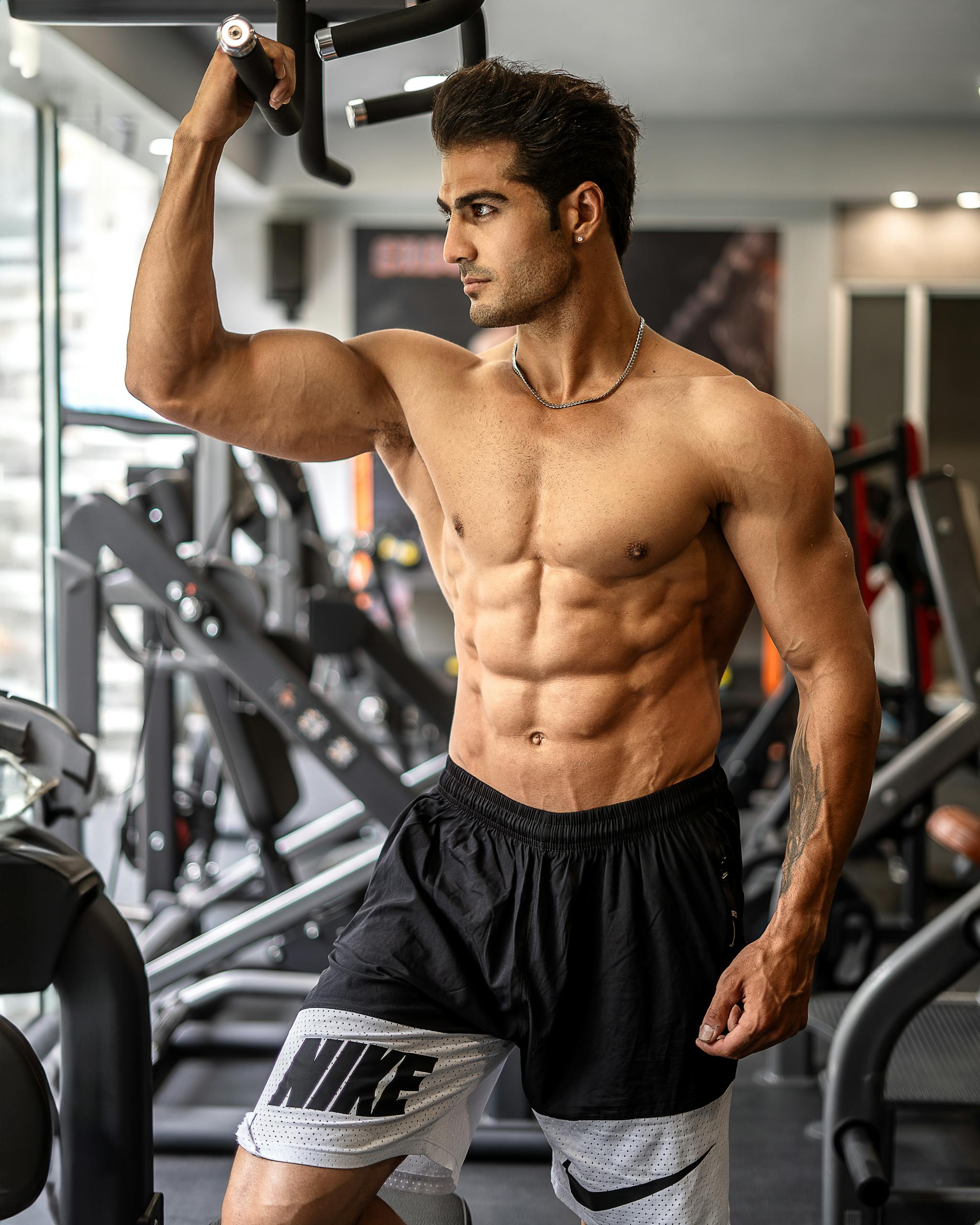 Young Muscular Man Standing Shirtless at the Gym after taking performance enhancing supplements